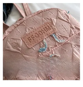 Close-up of quilted pink fabric with FFGDHM leather badge and colorful embroidery