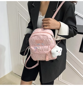 Pink embossed leather mini backpack with sequin bow and star charm worn by a model