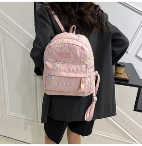 Pink quilted backpack for students with colorful embroidered bows and FFGDHM logo