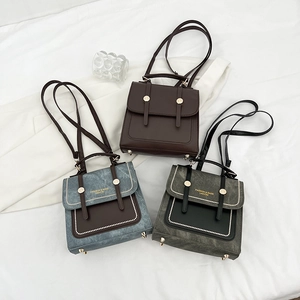 Three vintage multi-functional backpacks in brown, blue, and charcoal on white fabric
