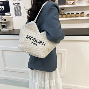 Woven straw tote bag with MOBORN PARIS text and white leather trim shoulder strap