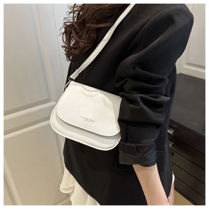 Detailed view of white minimalist square crossbody bag with Fashion Trend embossing