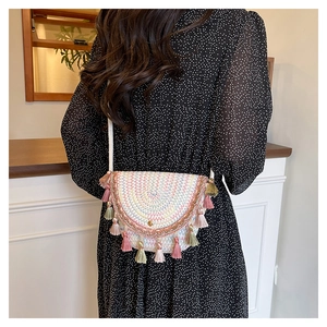 Détail du sac bandoulière tissé avec motifs de vagues colorées et pompons souples