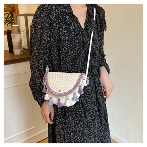 Detail of bohemian woven crossbody bag with colorful embroidery and fringe tassels