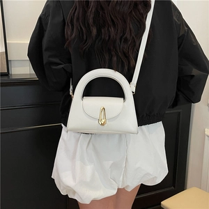 French vintage white crossbody bag with gold buckle shown on model in black and white outfit