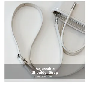 Macro shot of adjustable white leather shoulder strap with silver buckle and hook detail