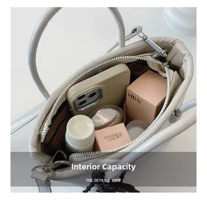 Top view of spacious interior of white bucket bag with brown lining and secure zipper