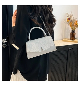 Detail view of silver glitter mini crossbody bag with metal V-buckle and chain strap