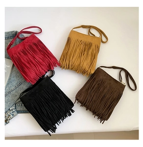 Flat lay of retro faux suede fringe bags in red, yellow, black and brown colors