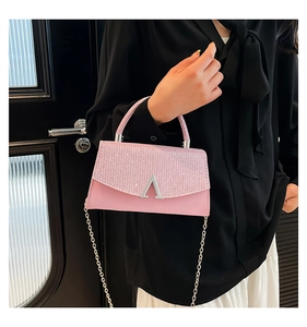 Détail du sac carré rose avec rabat pailleté, logo V en métal et bandoulière chaîne