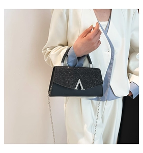 Détail d'un mini sac noir à paillettes avec rabat scintillant et boucle argentée en V