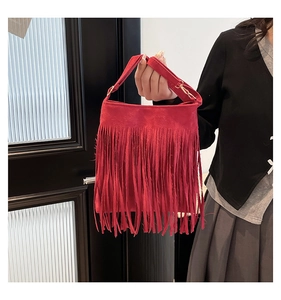 Close-up of red matte PU handbag featuring long decorative tassels and gold metal buckle