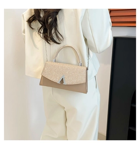 Detail showing glittery champagne texture, metallic V-clasp and elegant silver chain strap