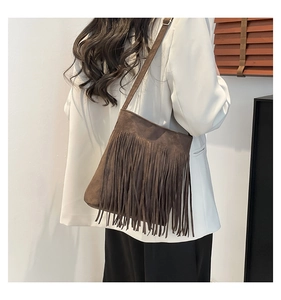 Detailed view of vintage dark brown suede shoulder bag with long bohemian fringes