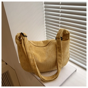 Detail of bright yellow corduroy dumpling bag texture and adjustable strap buckle