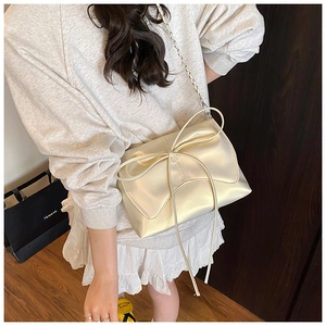 Détail du sac bandoulière doré champagne style ballet avec gros nœud et chaîne