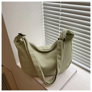 Detailed texture of light green corduroy tote bag with adjustable shoulder strap