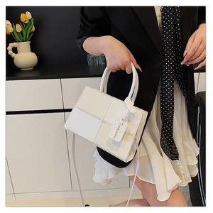 Detail of white rectangular patchwork crossbody bag with fashion tag and top handle