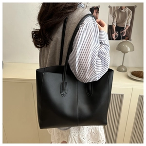 Close-up of minimalist black tote bag with vertical stitching for commuter use