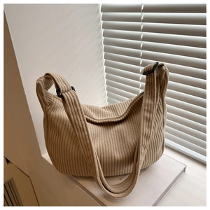 Detail of adjustable strap and buckle on a beige corduroy large crossbody hobo bag