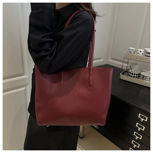 Shoulder view of a large burgundy tote bag in matte synthetic leather for commuting