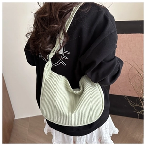 Detailed texture of light green corduroy hobo bag showing the soft crescent shape