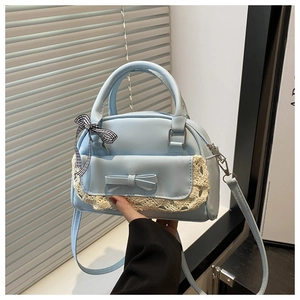 Detail of light blue bow handbag with white lace trim and checkered scarf on handle