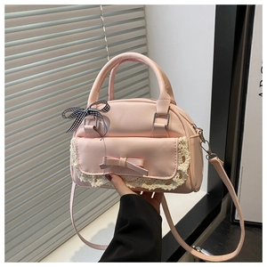 Detailed view of pink PU leather handbag with lace trim and bowknot accents