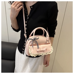 Pink bow handbag with lace trim and ribbon detail shown worn as a crossbody bag