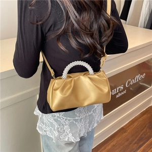 Chic pleated cloud bag with white pearl handle and crossbody strap in matte gold finish