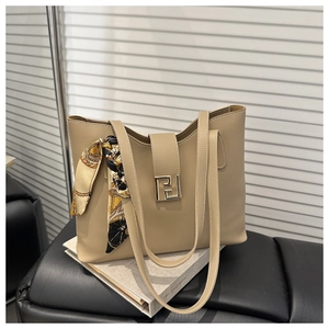 Detail of khaki tote bag with silk scarf accessory and square golden metal buckle