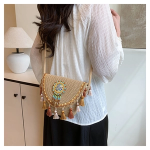 Detail view of a woven straw bag featuring colorful bead patterns and long decorative tassels
