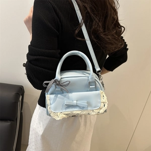 Blue bow Boston handbag with lace trim and adjustable crossbody strap for summer style