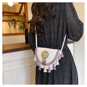 Detail of bohemian woven shell bag featuring colorful beaded mandala and purple tassels