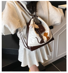Détail du sac cabas blanc et marron avec motifs chats et porte-clés de baseball