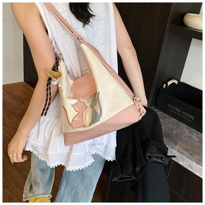 Détail du cabas rose et beige avec applique chat et foulard en soie rayé élégant
