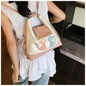 Détail du sac à main patchwork rose et beige avec silhouette de chat et fines bandoulières