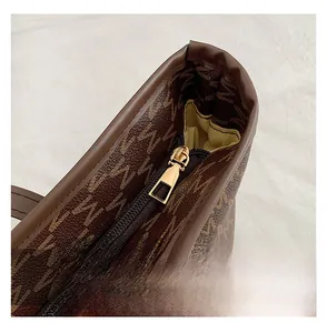Detail shot of the golden metal zipper closure on the brown monogram tote bag