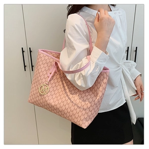 Detailed side view of pink tote bag with M-pattern print and golden logo charm pendant