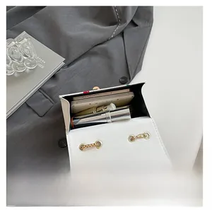 Detail view showing interior capacity for phone and lipstick in white cherry print bag