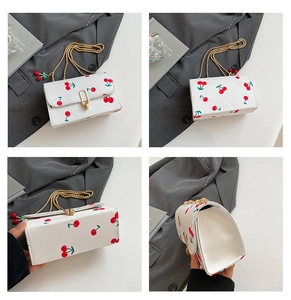 Detail view of white saddle bag with cherry print and golden chain strap from multiple angles