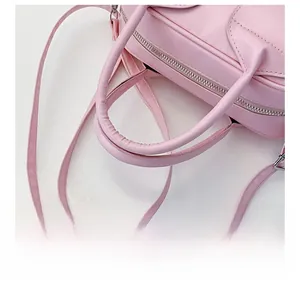 Close-up of comfortable shoulder strap connection and texture on pink shell bag