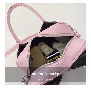 Internal capacity of pink and black shell bag with phone and cosmetics storage view