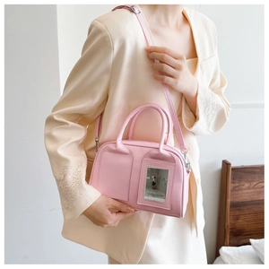 Detail of light pink shell crossbody bag with transparent card slot and silver metal buckle