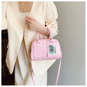 Detailed side view of a pink shell-shaped crossbody bag with transparent card slot detail