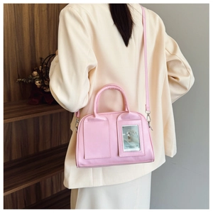 Detailed side view of pink shell bag with clear card slot on a smooth leather finish
