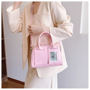 Detail of light pink shell bag showing front photo window and smooth faux leather texture