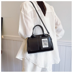 Detail of black faux leather shell bag with adjustable strap and decorative card slot