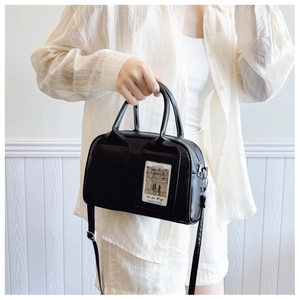 Detail of black PU shell bag featuring a transparent card slot and silver hardware