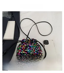 Détail macro d'un sac seau en paillettes colorées avec fermeture à cordon serrage